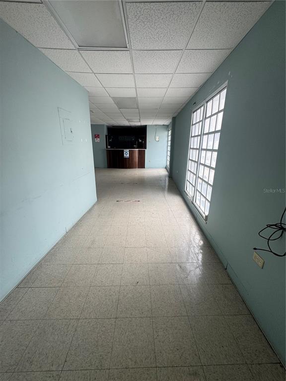 An empty commercial space features light blue walls, a drop ceiling, and tiled flooring — Pavia Medical Plaza AMÉRICO SALAS, SAN JUAN, PR