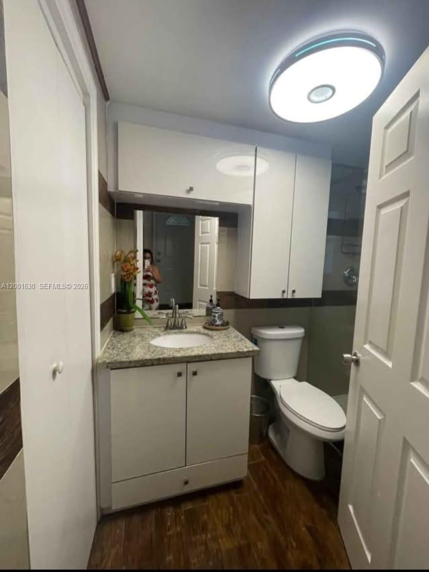 A bathroom features a granite vanity, white cabinets, a toilet, and a circular ceiling light — 315 NW 59th St # 1, Miami FL 33127, MIAMI, FL