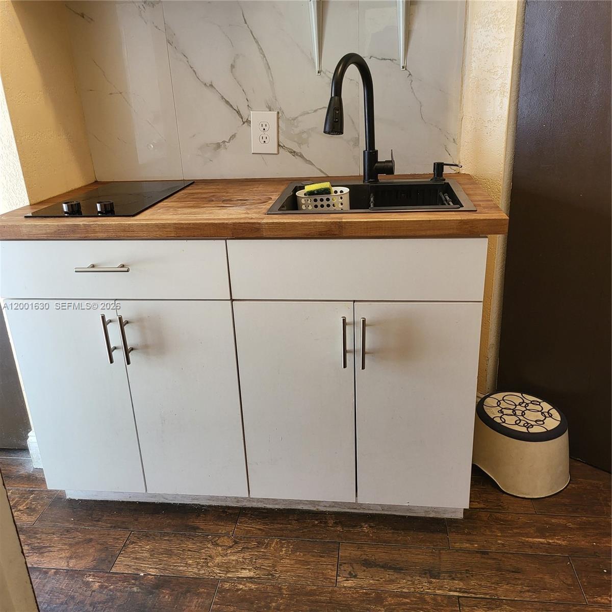 A small kitchen kitchenette features a wooden countertop, a black sink, and a stovetop — 315 NW 59th St # 1, Miami FL 33127, MIAMI, FL
