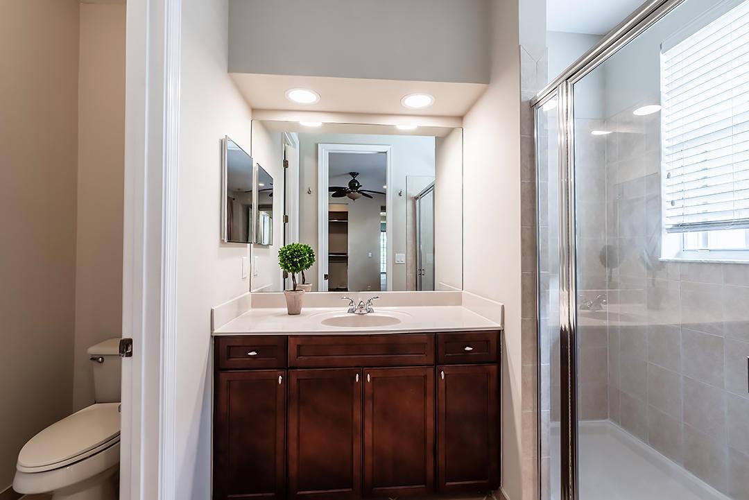A bathroom features a dark wood vanity, a large mirror, and a glass-enclosed shower — 2502 NW 4th Street, Boynton Beach FL 33426, BOYNTON BEACH, FL