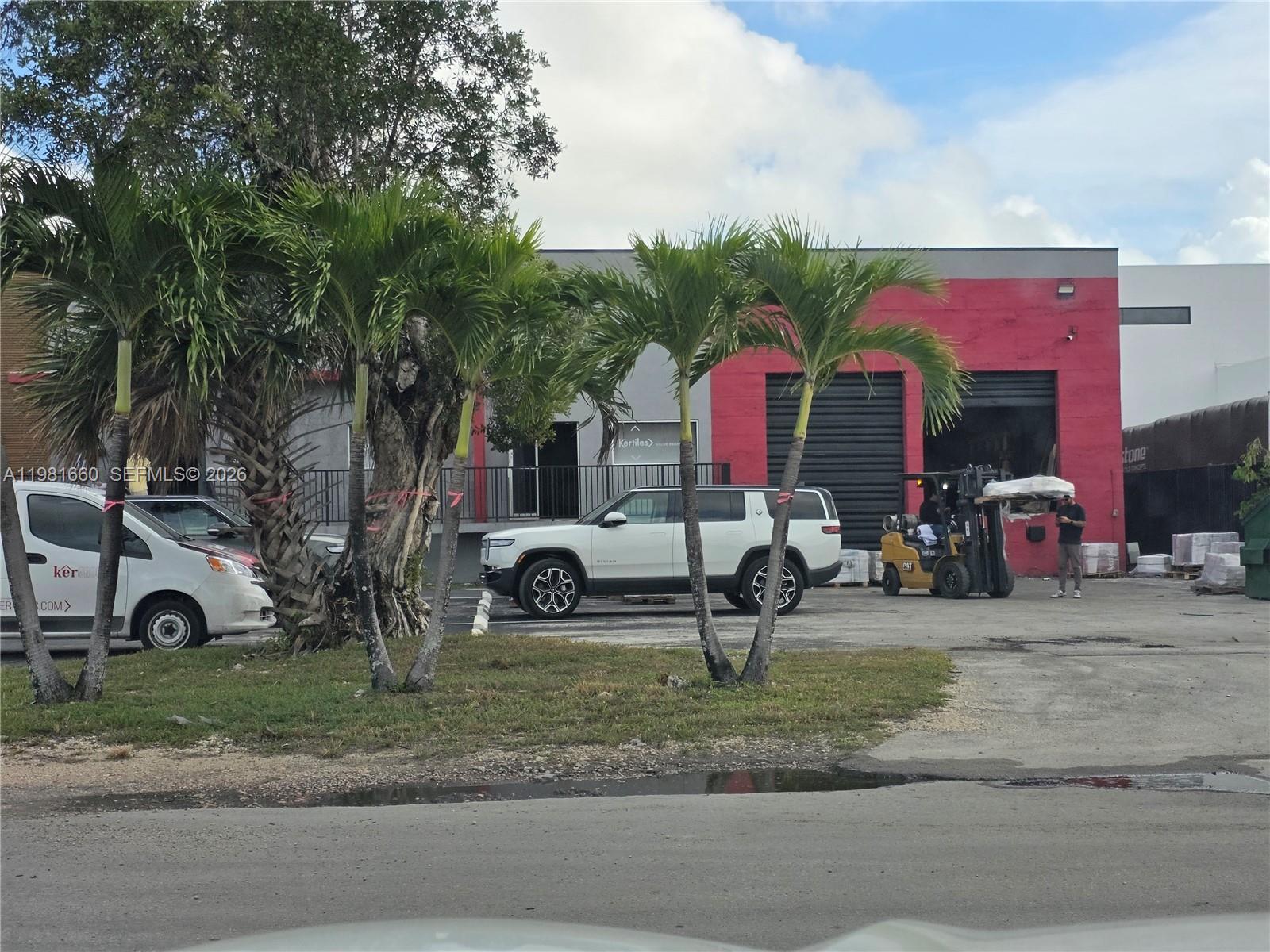 A white SUV is parked in front of a commercial building with a red facade — 3281 NW 78th Ave, Doral FL 33122, DORAL, FL