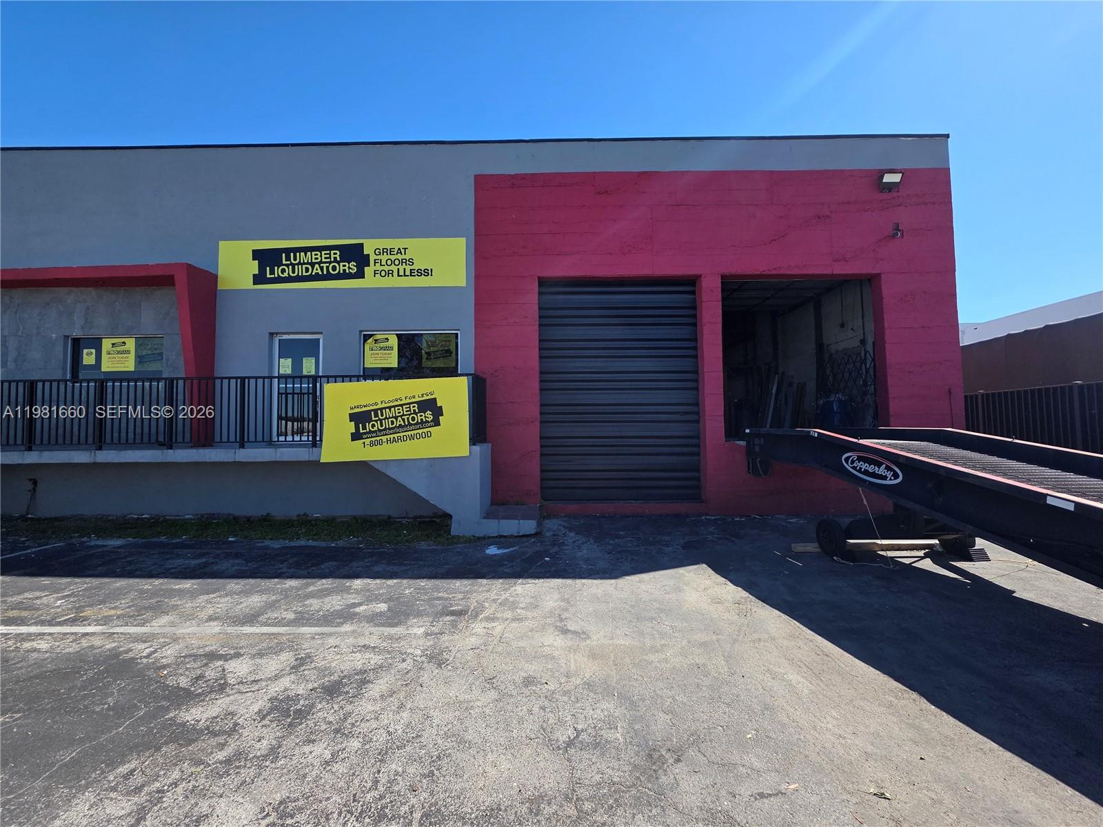 The exterior of a commercial building features a loading dock and Lumber Liquidators signage — 3281 NW 78th Ave, Doral FL 33122, DORAL, FL