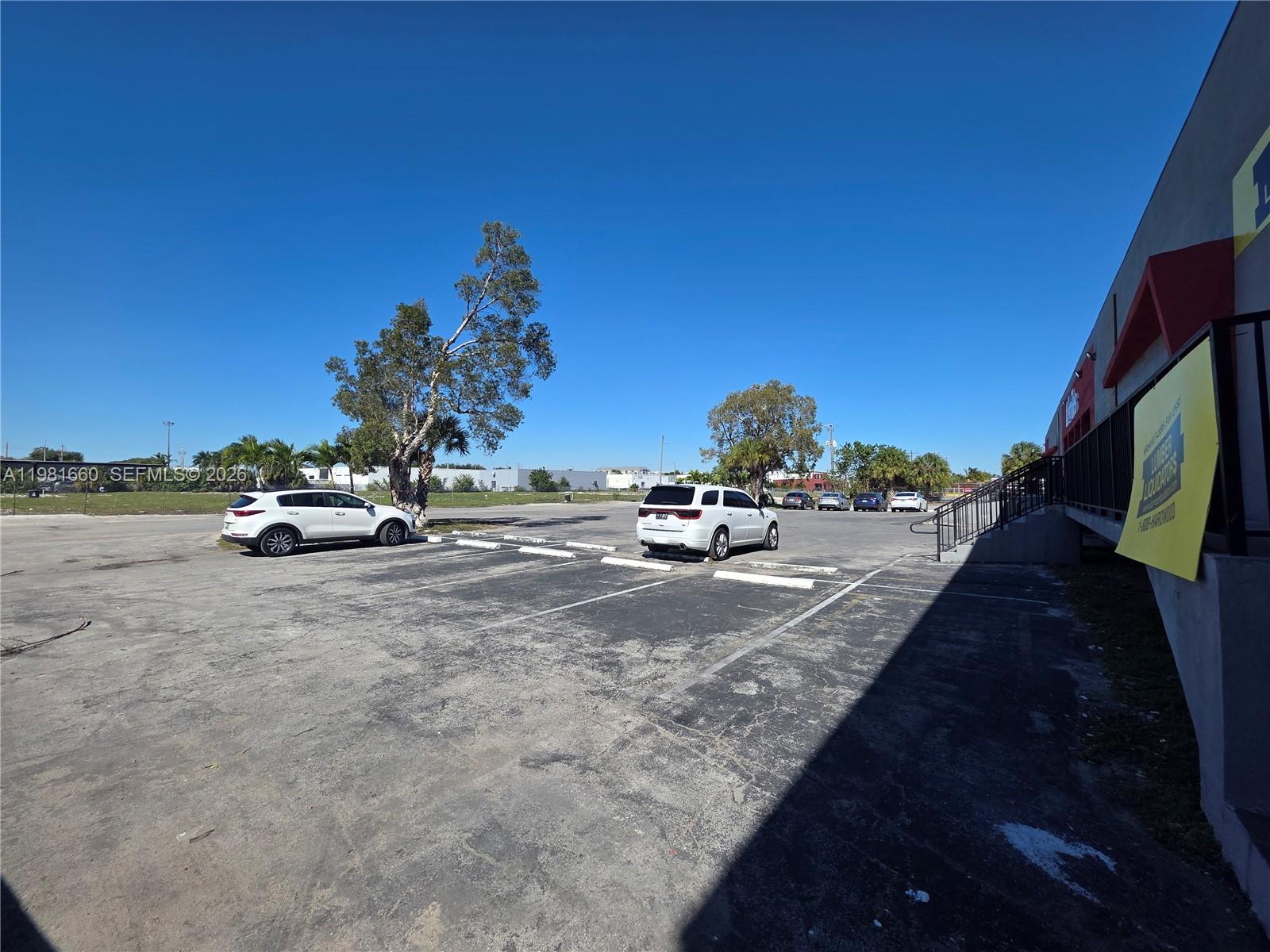 A paved parking lot sits in front of a commercial building under a clear sky — 3281 NW 78th Ave, Doral FL 33122, DORAL, FL