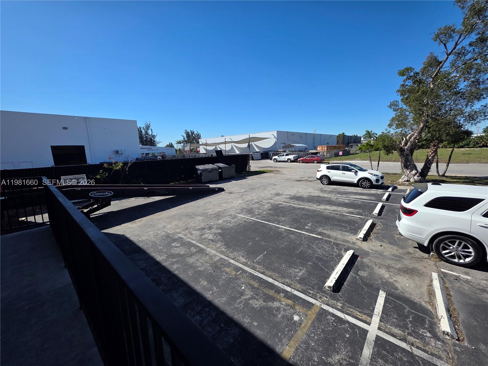 An outdoor parking lot features marked spaces, a trailer, and two white SUVs — 3281 NW 78th Ave, Doral FL 33122, DORAL, FL