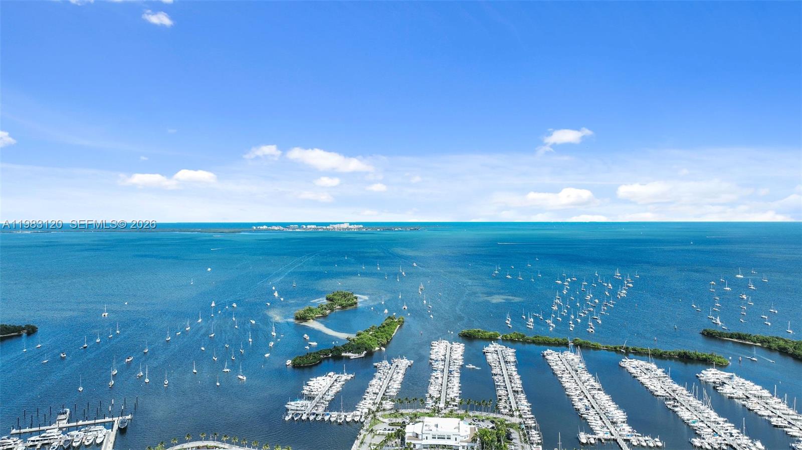 An aerial view shows a marina with numerous boats docked along piers in a bay — 2678 Tigertail Ave # 1705, Miami FL 33133, MIAMI, FL