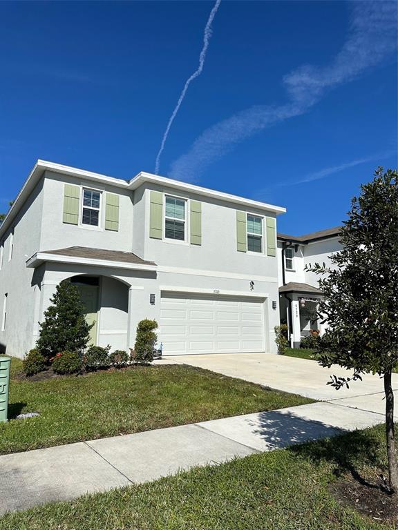 A two-story house with light gray stucco siding and a two-car garage — 5703 HOLLINGWORTH TRAIL, WESLEY CHAPEL, FL