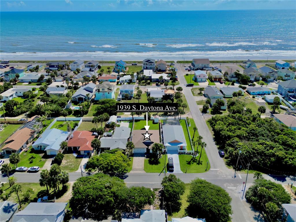 An aerial view shows a residential house near the beach with surrounding homes and vegetation — 1939 S DAYTONA AVENUE, FLAGLER BEACH, FL