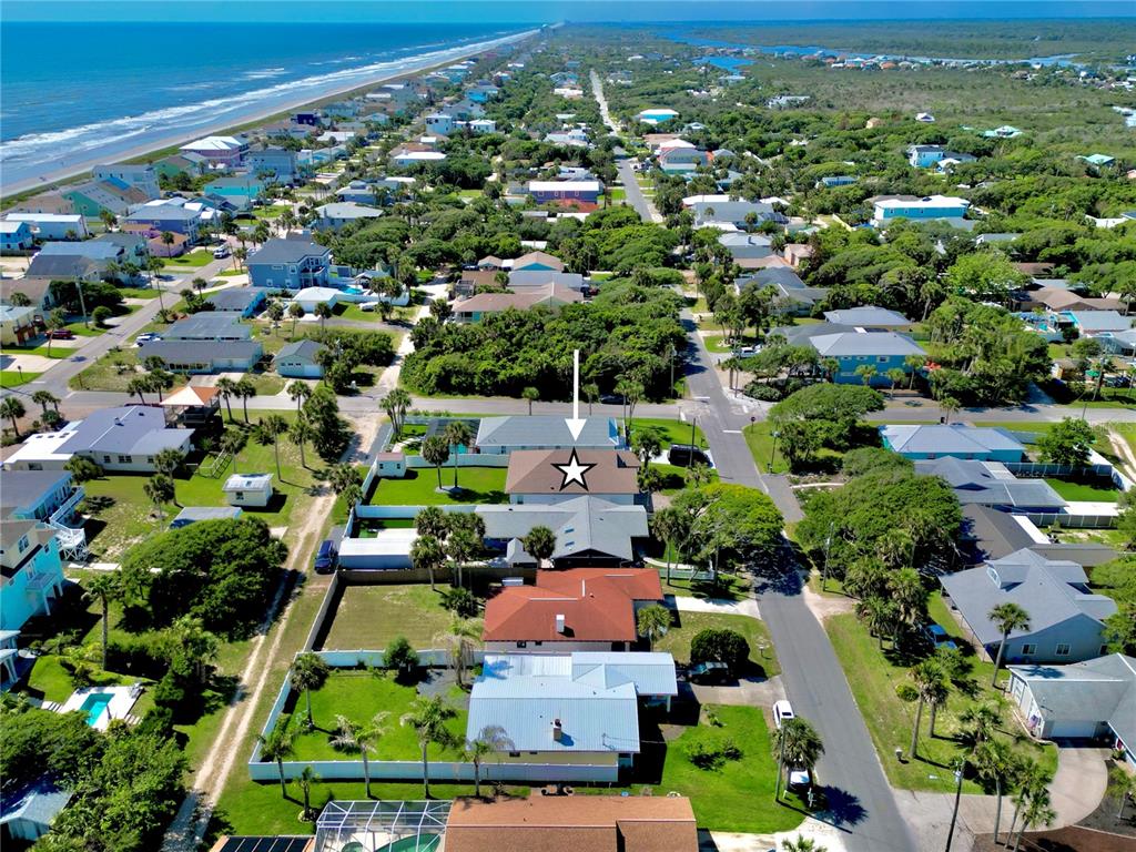 An aerial view shows a residential neighborhood near the coast with a marked house — 1939 S DAYTONA AVENUE, FLAGLER BEACH, FL