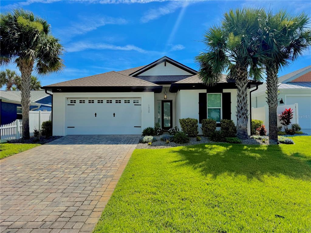 A single-story house with a white exterior, a two-car garage, and two palm trees — 1939 S DAYTONA AVENUE, FLAGLER BEACH, FL
