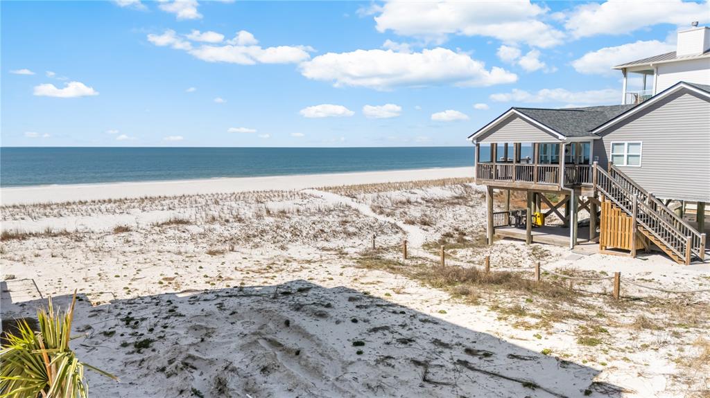 A stilted beach house overlooks a sandy dune and the ocean under a blue sky — 1817 HIGHWAY 98, MEXICO BEACH, FL