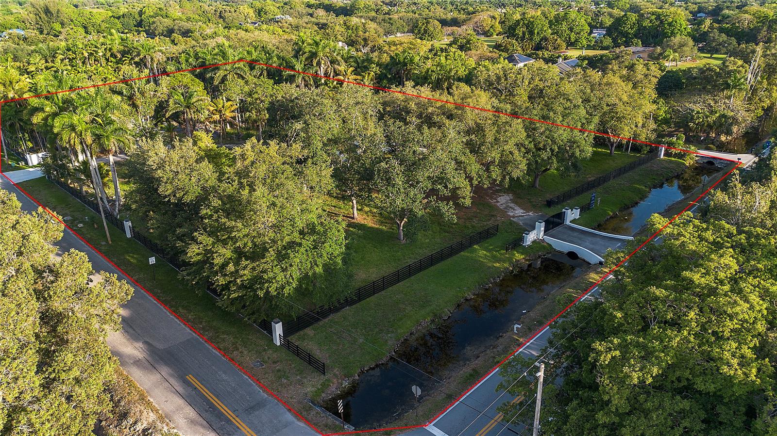 An aerial view shows a wooded, fenced residential lot bordered by roads and a canal — 6541 Melaleuca Rd, Southwest Ranches FL 33330, SOUTHWEST RANCHES, FL