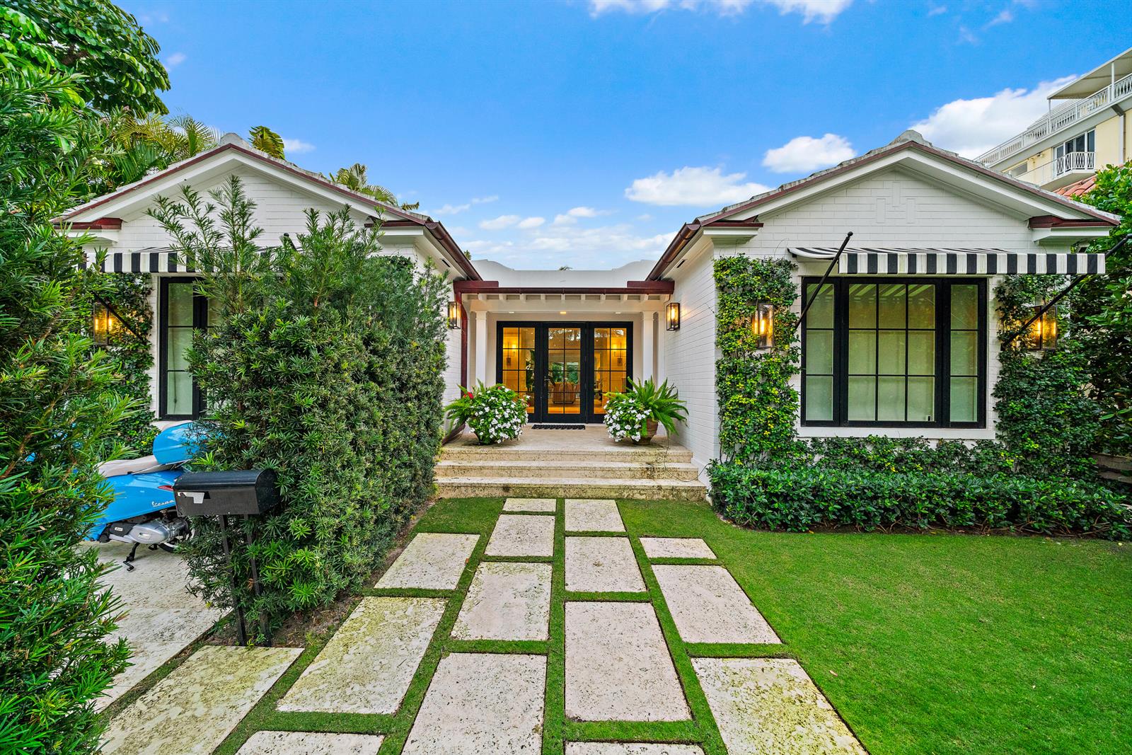 A white brick house with black-framed windows, striped awnings, and a stone walkway — 160 Chilean Avenue, Palm Beach FL 33480, PALM BEACH, FL
