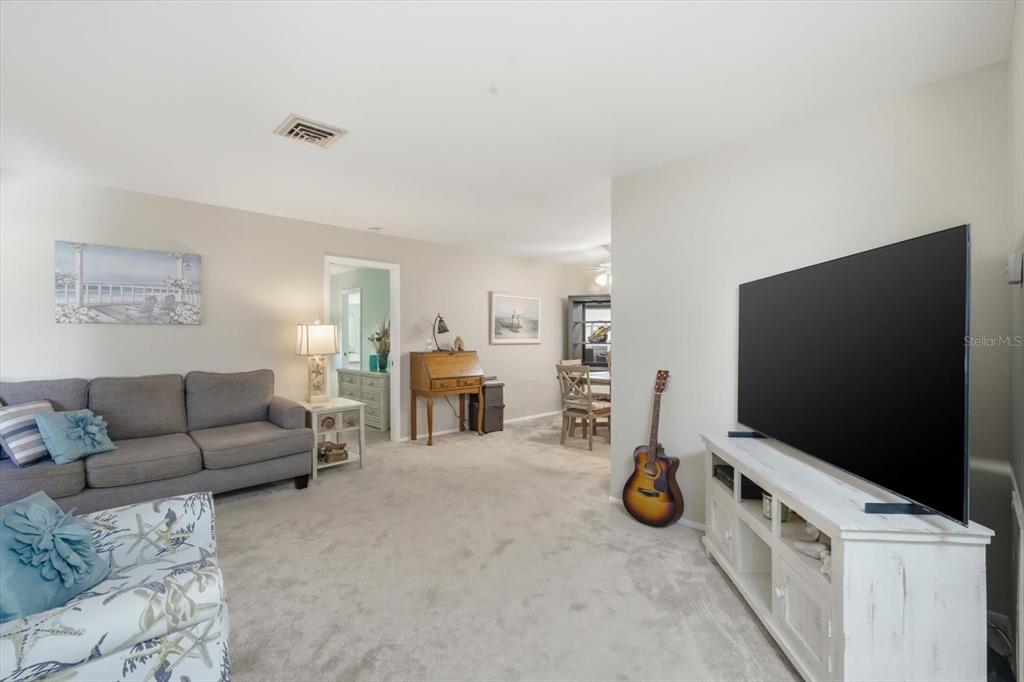 A single-story house with a tan exterior, two garage doors, and a landscaped front yard — 6108 PENNY LANE, BRADENTON, FL