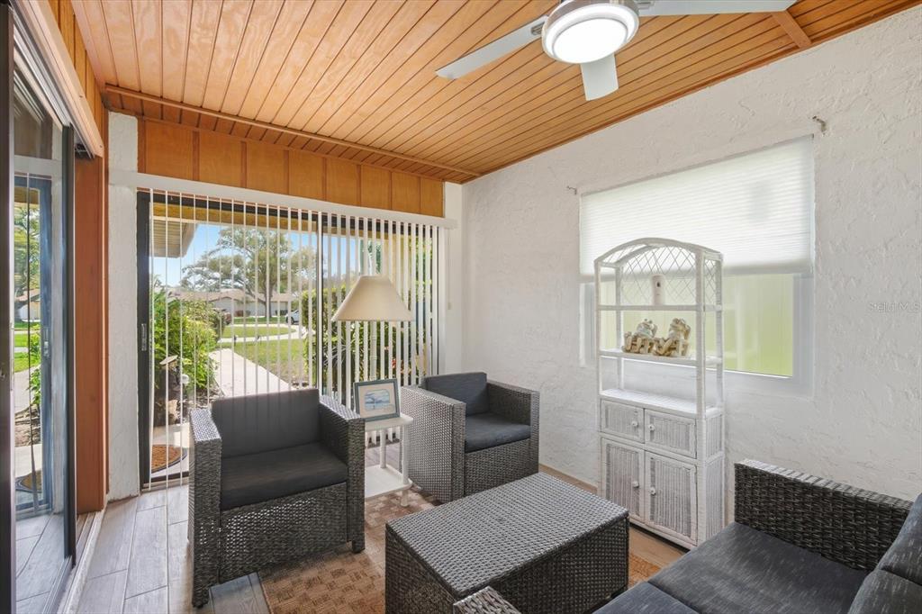 A home office with wood-paneled walls, a wood-plank ceiling, and a desk facing a window — 6108 PENNY LANE, BRADENTON, FL