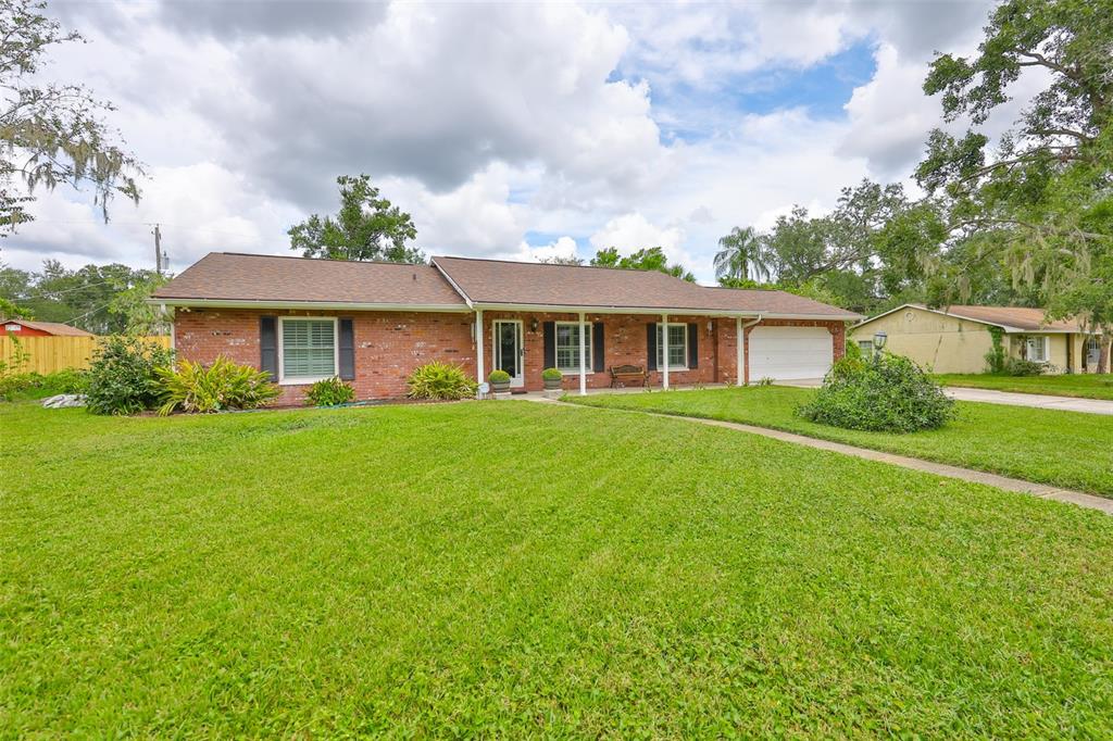 A single-story brick house with a white garage and a large front lawn — 1408 MOSS LADEN COURT, BRANDON, FL