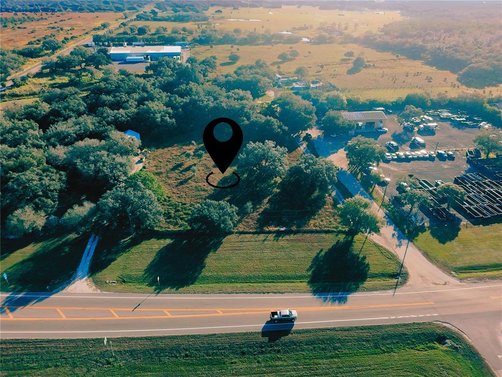 An aerial view shows a vacant, tree-lined lot marked with a pin beside a road — N Sr 29 N SR 29, LABELLE, FL
