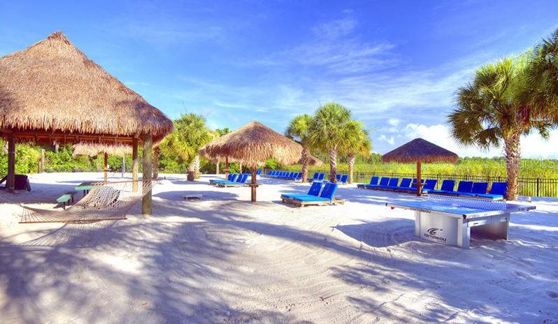 A sandy beach area features thatched-roof cabanas, lounge chairs, and a ping-pong table — 802 GRAN BAHAMA BOULEVARD UNIT 802, DAVENPORT, FL