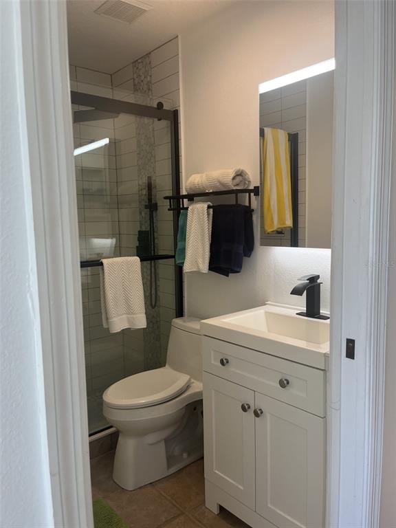 A small bathroom features a white vanity, a toilet, and a glass-enclosed shower — 9400 LITTLE GASPARILLA ISLAND UNIT A7, PLACIDA, FL