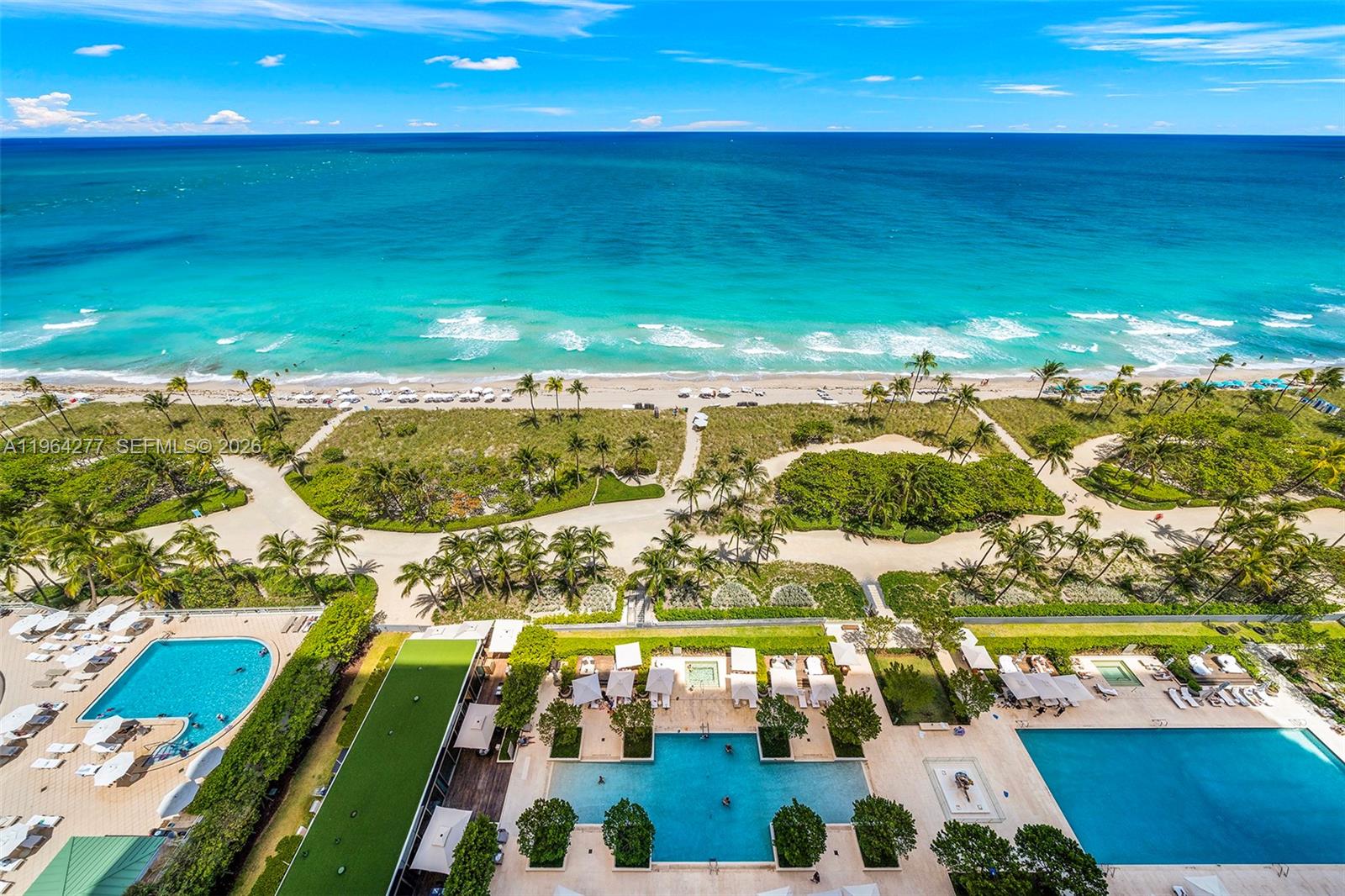An aerial view shows multiple swimming pools, a sandy beach, and the ocean — 10203 Collins Ave # 1602, Bal Harbour FL 33154, BAL HARBOUR, FL