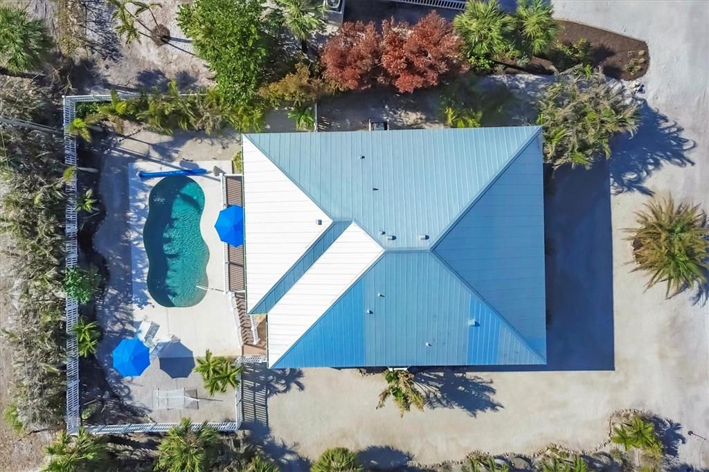 An aerial view shows a house with a blue metal roof, a pool, and landscaping — 2420 24TH STREET W, BOCA GRANDE, FL