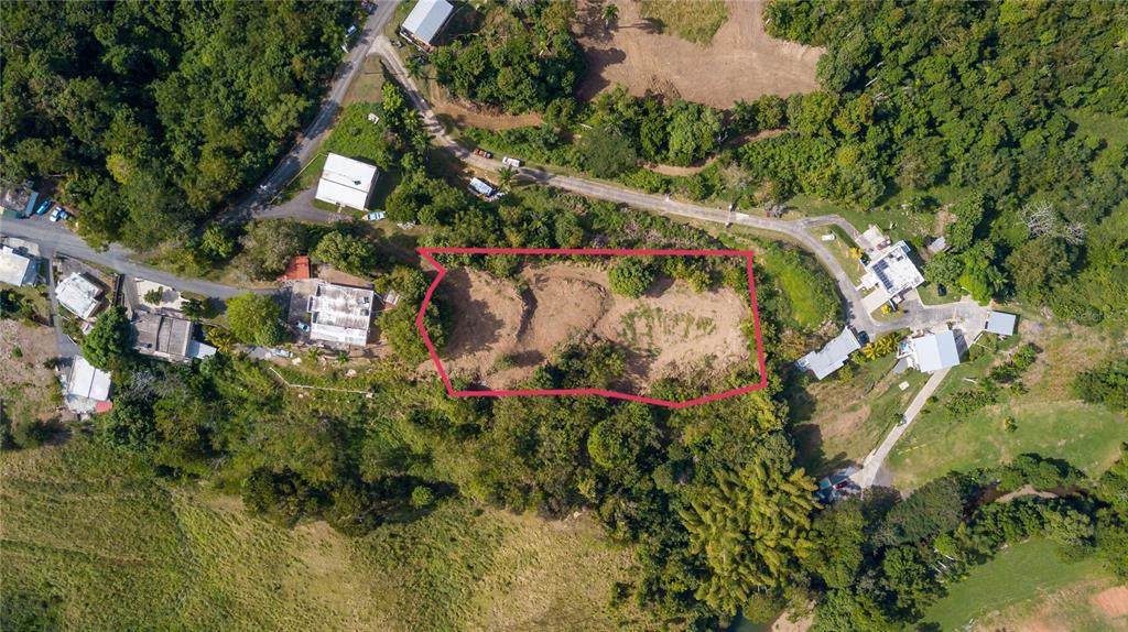 An aerial view shows a cleared, rectangular plot of land outlined in red amidst greenery — Solar B BARRIO JAGÜEY, AGUADA, PR
