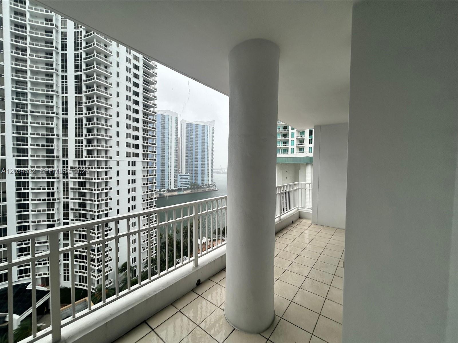 A balcony with a white pillar overlooks a waterway and high-rise buildings — 801 Brickell Key Blvd # 1710, Miami FL 33131, MIAMI, FL