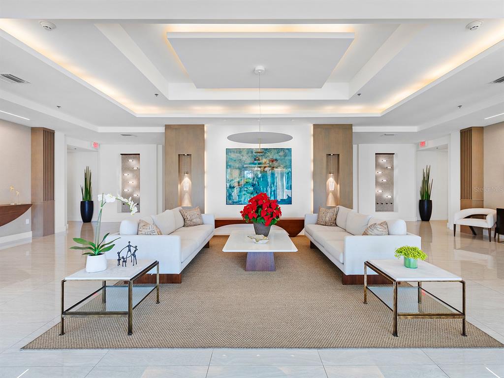 A light blue double door with glass panels sits beside a wooden decorative stand — 3040 GRAND BAY BOULEVARD UNIT 213, LONGBOAT KEY, FL