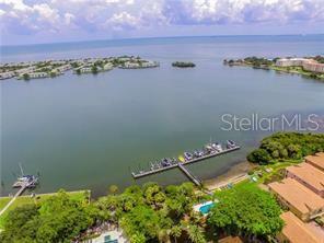 An aerial view shows a boat dock extending into a bay near residential buildings — 184 BANYAN BAY DRIVE, ST PETERSBURG, FL