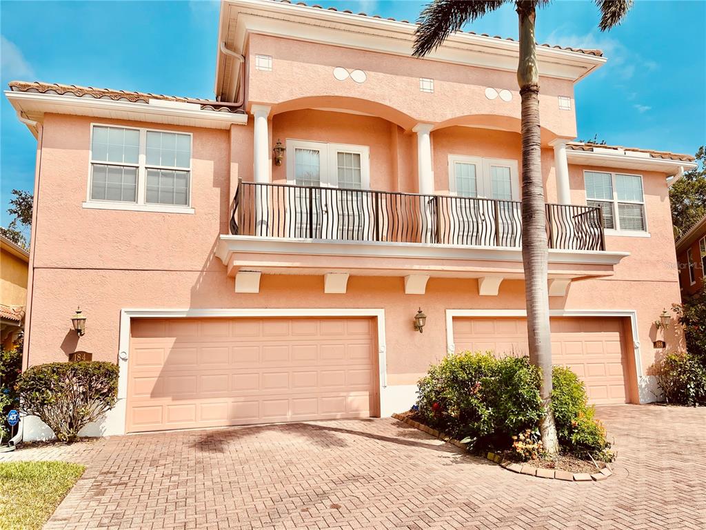 A two-story peach-colored house features a three-car garage and a second-floor balcony — 184 BANYAN BAY DRIVE, ST PETERSBURG, FL