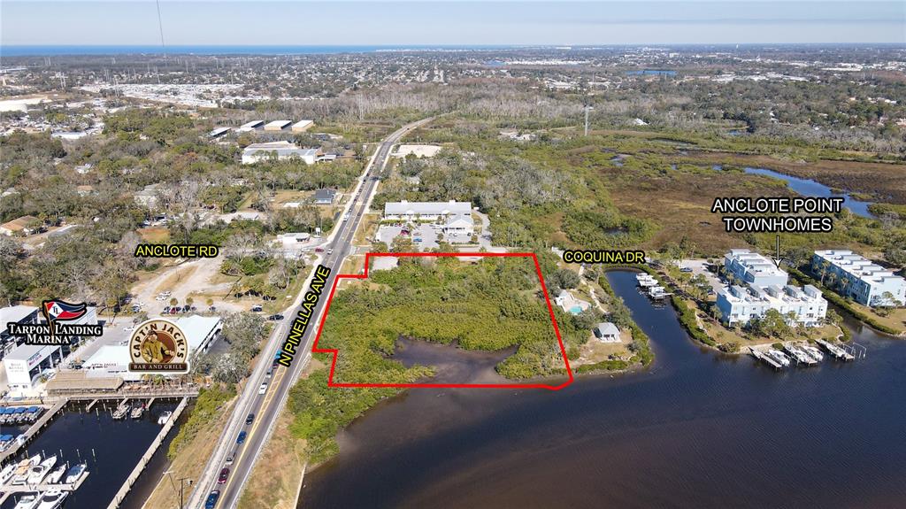 This aerial view shows a vacant waterfront lot outlined in red next to a marina — N PINELLAS AVENUE, TARPON SPRINGS, FL