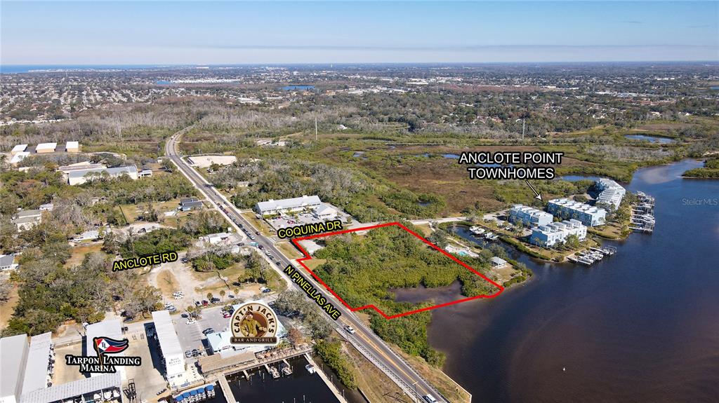 An aerial view shows a vacant waterfront lot outlined in red near a marina — N PINELLAS AVENUE, TARPON SPRINGS, FL