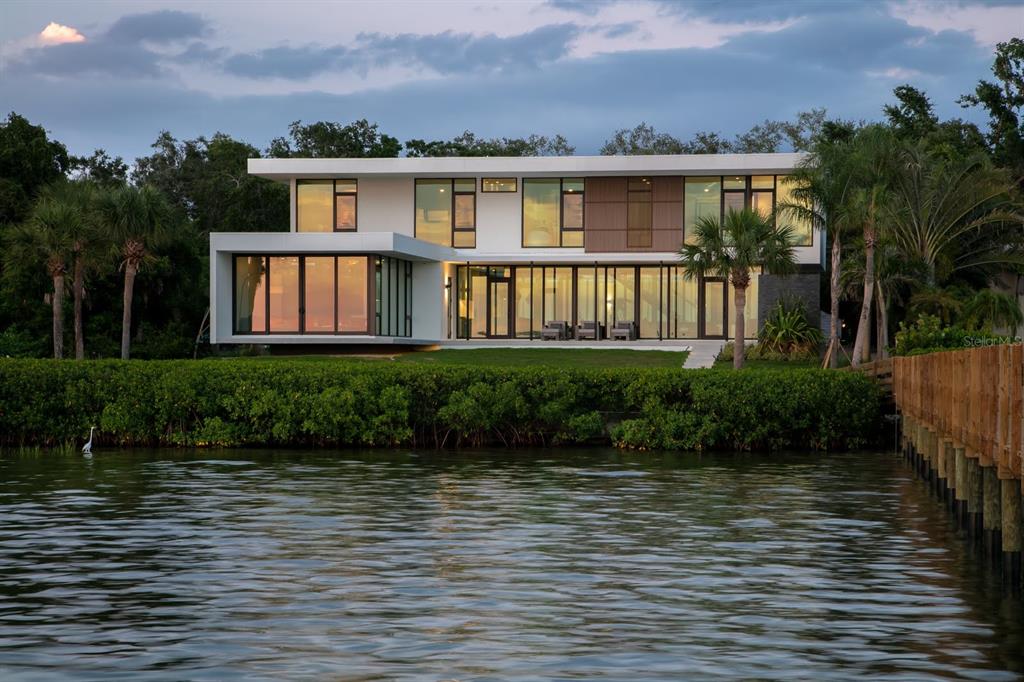 A modern two-story waterfront home with large glass windows and a flat roof — 1500 BAYVIEW DRIVE, SARASOTA, FL