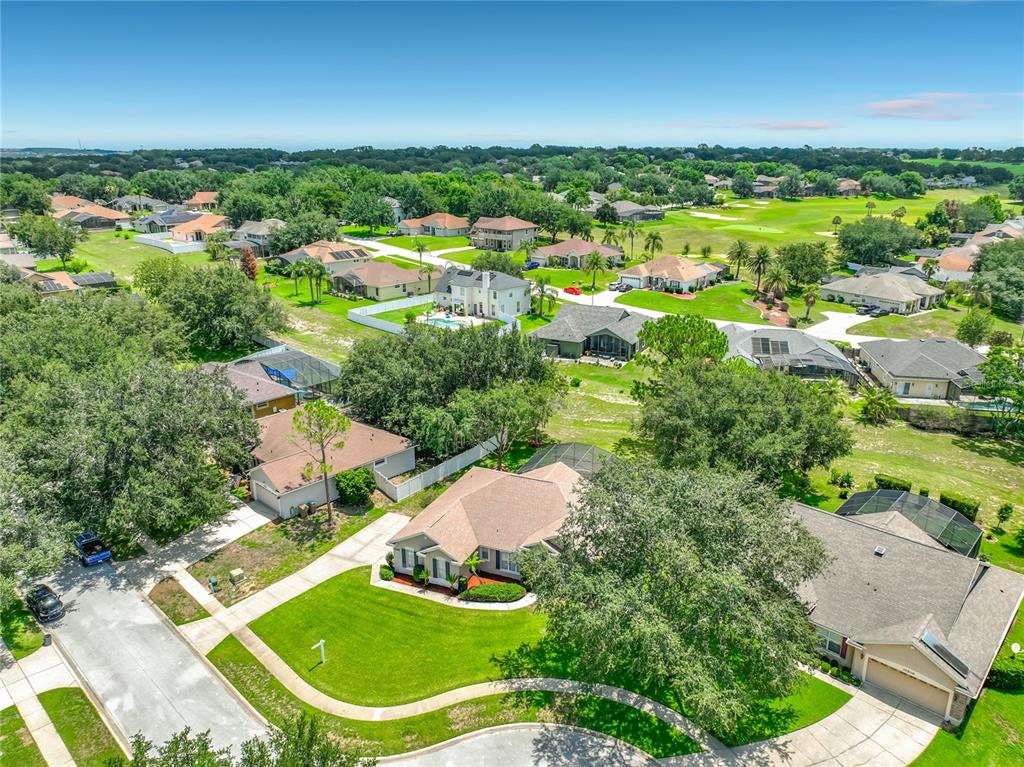 An aerial view shows suburban houses with swimming pools and lawns near a golf course — 10512 VIA MILANO COURT, CLERMONT, FL