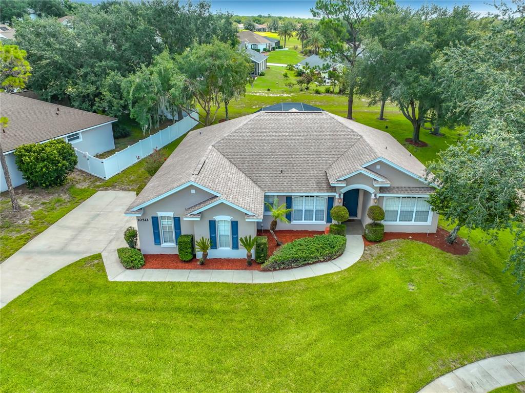 An aerial view of a single-story house with a tan exterior and a shingled roof — 10512 VIA MILANO COURT, CLERMONT, FL