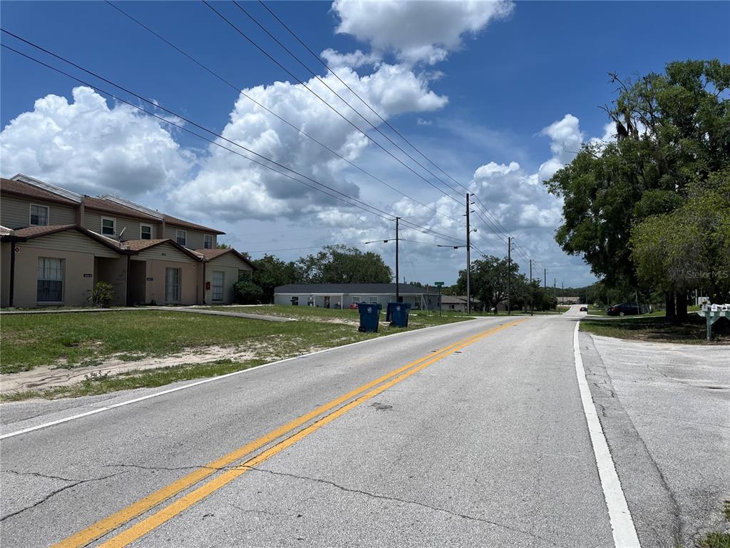A street view shows a multi-family residential building, power lines, and a paved road — PINEHURST DRIVE, SPRING HILL, FL