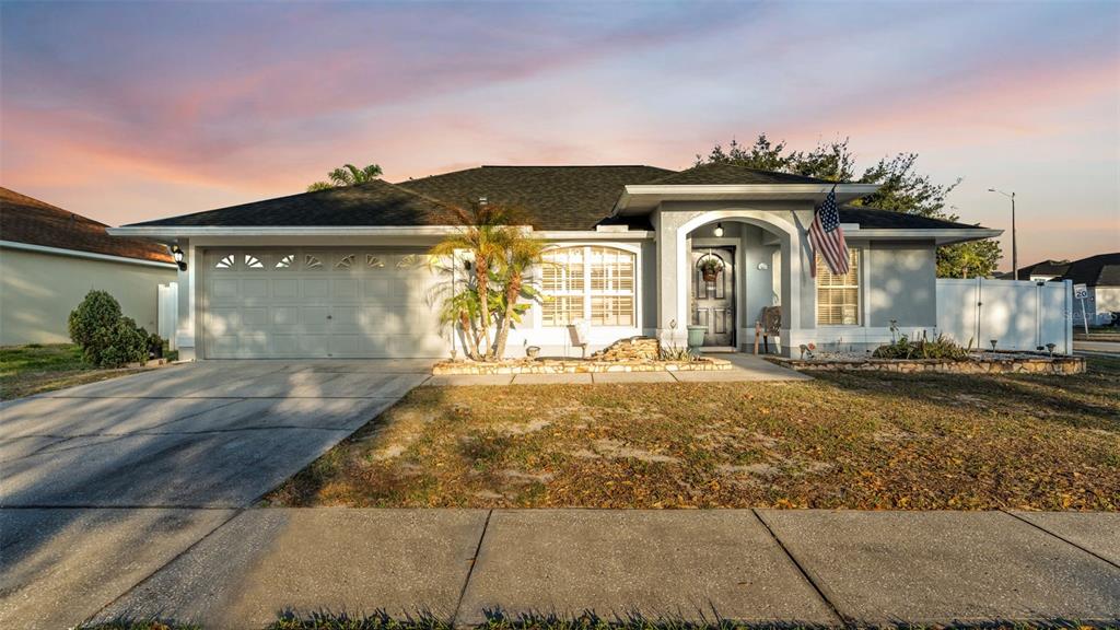 A single-story suburban house with a two-car garage, arched entryway, and a front lawn — 5410 LINDBURG STREET, RIVERVIEW, FL