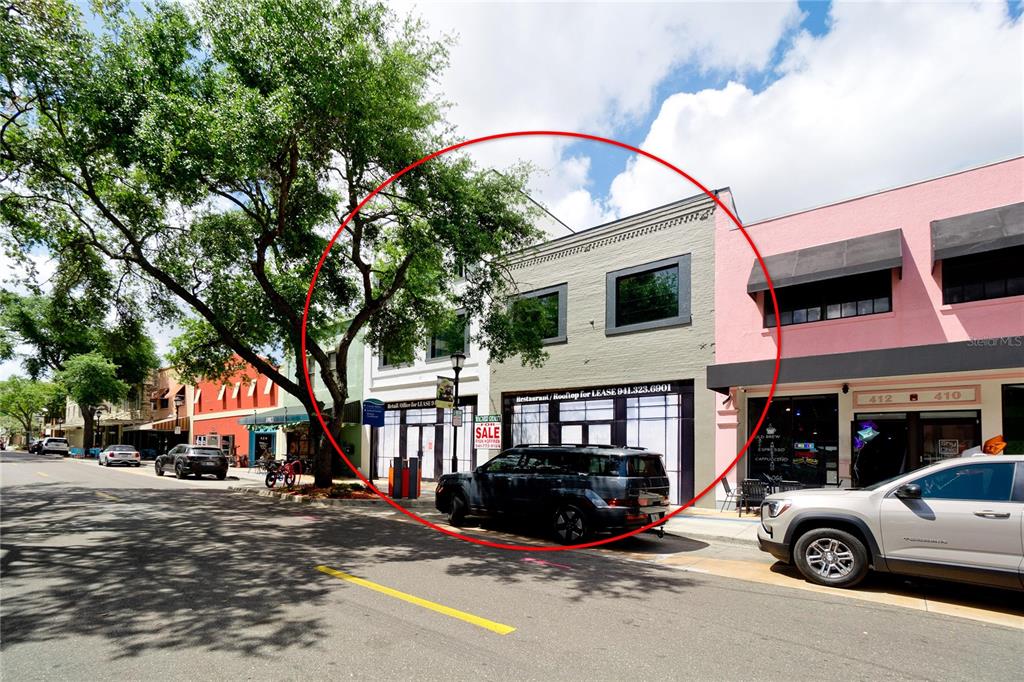 A two-story commercial building with a gray facade and a black SUV parked in front — 416-420 12TH STREET W, BRADENTON, FL