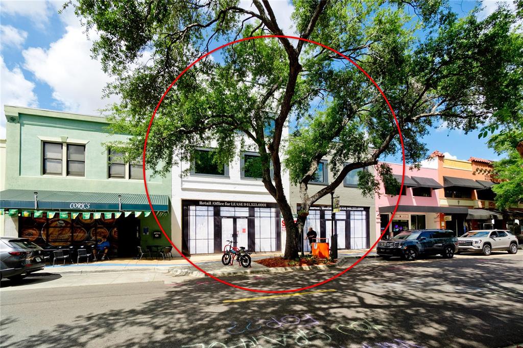 A white two-story commercial building with a large tree in front on a street — 416-420 12TH STREET W, BRADENTON, FL