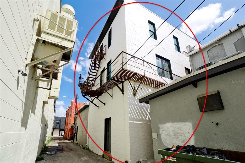 A white brick building exterior features a metal fire escape and a balcony in an alley — 416-420 12TH STREET W, BRADENTON, FL