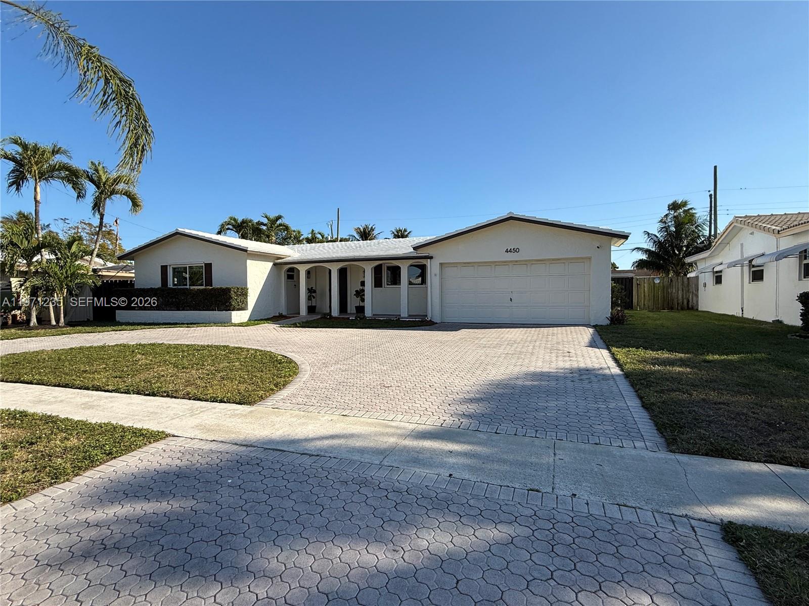 A single-story house with a white exterior, a paved driveway, and palm trees — 4450 NW 9th St, Coconut Creek FL 33066, COCONUT CREEK, FL