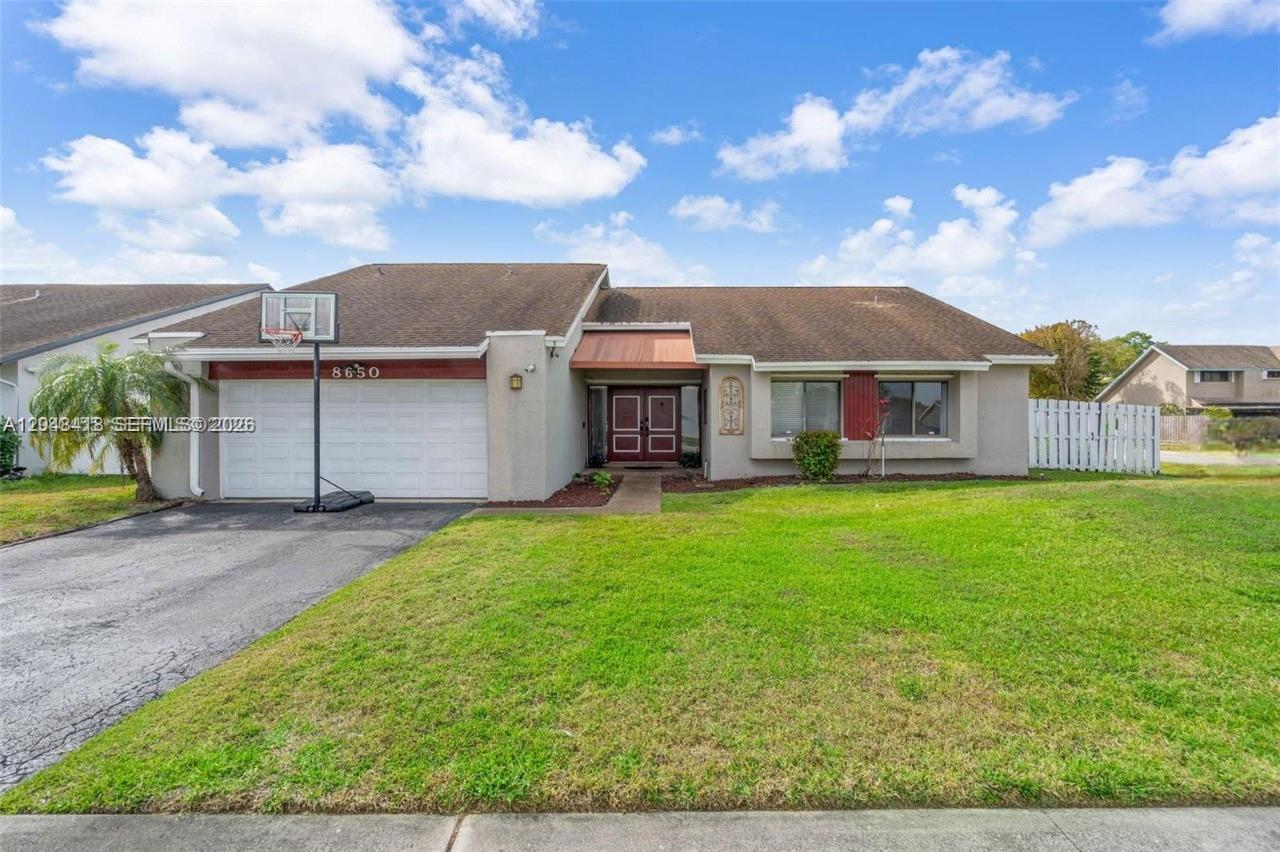 A single-story house with a two-car garage, a front lawn, and a paved driveway — 8650 NW 46th Ct, Lauderhill FL 33351, LAUDERHILL, FL