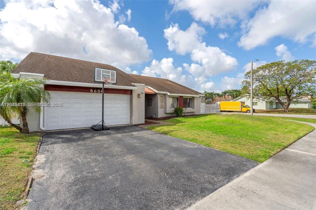A single-story house with a white garage door, a basketball hoop, and a paved driveway — 8650 NW 46th Ct, Lauderhill FL 33351, LAUDERHILL, FL