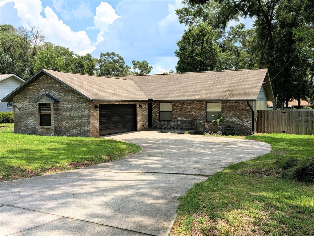 A single-story brick house with a two-car garage and a concrete driveway — 3243 NE 32ND AVENUE, OCALA, FL