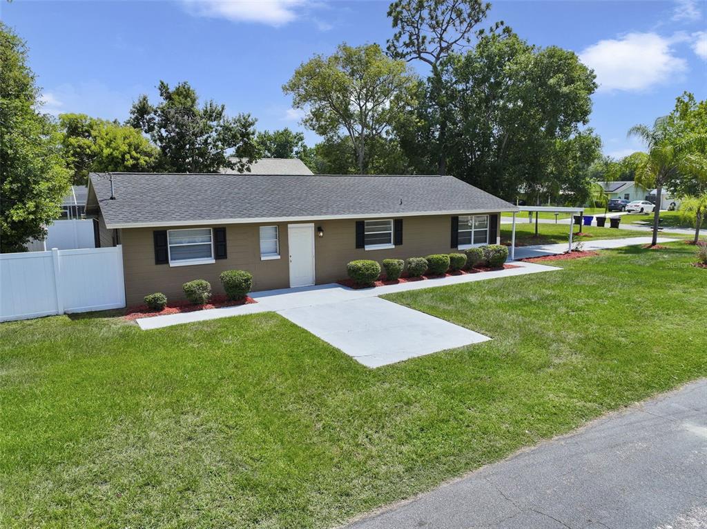 A single-story house with brown siding, a dark shingled roof, and a concrete walkway — 601 LOUISIANA AVENUE, ST CLOUD, FL