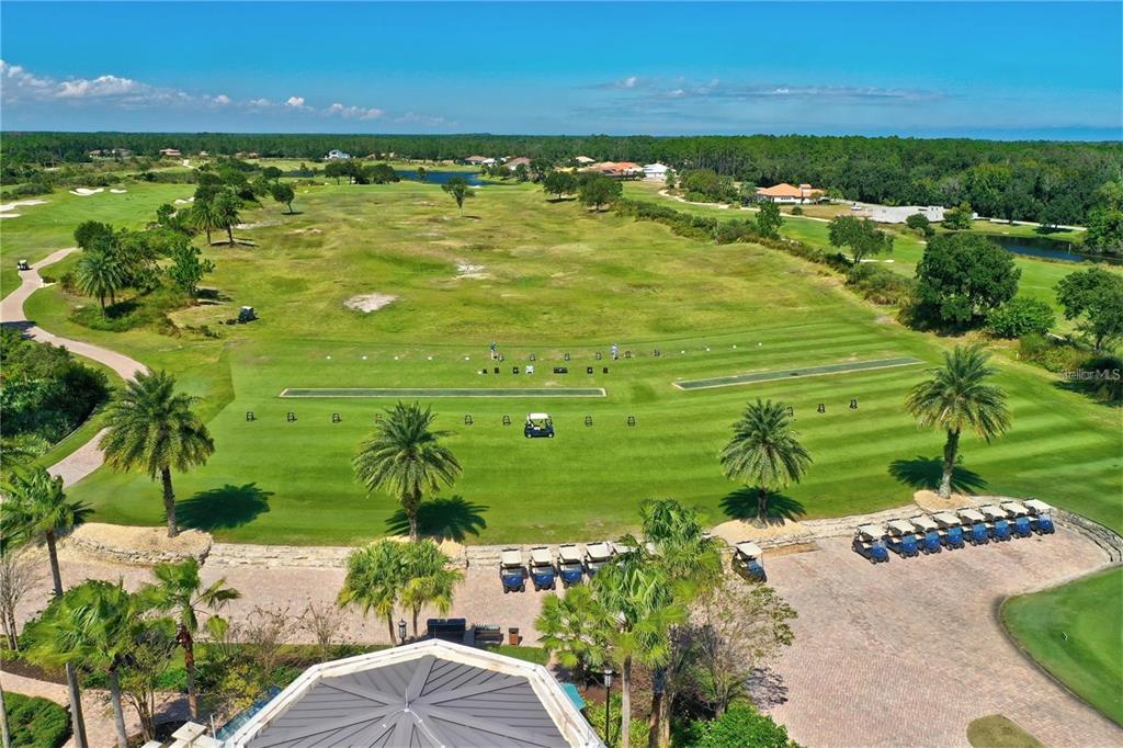 An aerial view shows a golf course driving range with palm trees and golf carts — 491 SWEETGUM LANE, PALM COAST, FL