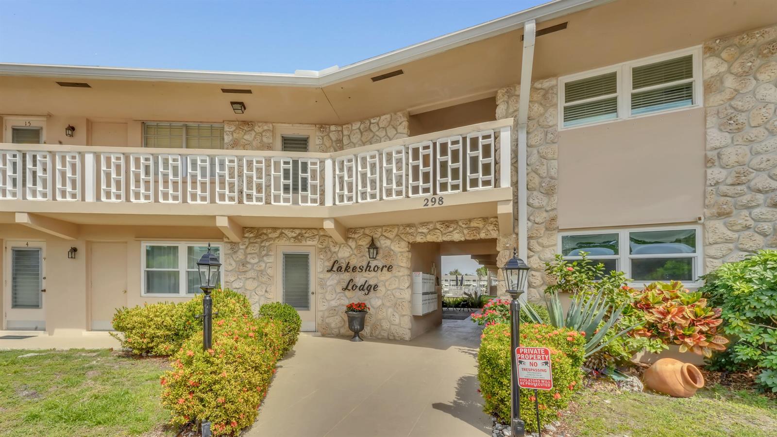 The exterior of a two-story apartment building features stone accents, a balcony, and a walkway — 298 SE 6th Avenue # 2, Pompano Beach FL 33060, POMPANO BEACH, FL