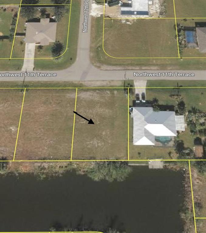 This aerial map shows a vacant residential lot situated next to a house and pond — 1210 NW 11TH TERRACE, CAPE CORAL, FL