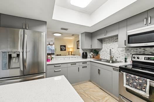 A modern kitchen features gray cabinets, stainless steel appliances, and a white quartz countertop — 20930 SW 83rd Ave, Cutler Bay FL 33189, CUTLER BAY, FL