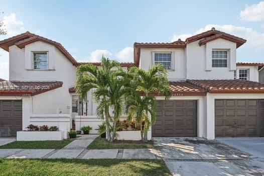 A two-story house with white stucco walls, brown tile roofs, and two garage doors — 20930 SW 83rd Ave, Cutler Bay FL 33189, CUTLER BAY, FL