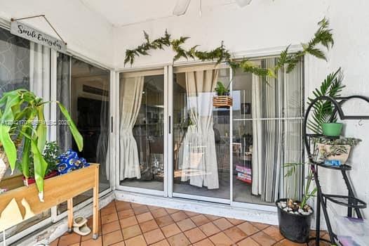 A tiled patio features sliding glass doors, a wooden planter, and a metal plant stand — 20930 SW 83rd Ave, Cutler Bay FL 33189, CUTLER BAY, FL
